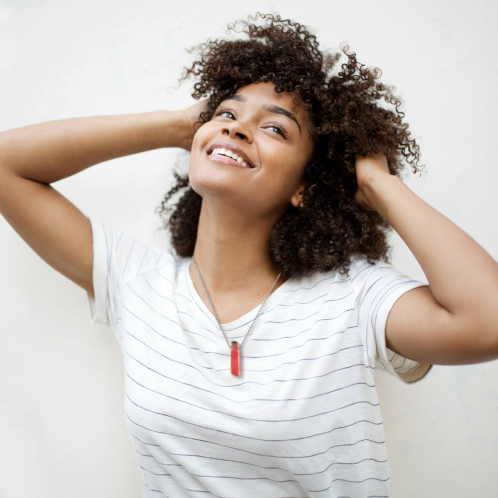 happy young lady wearing a gemstone pendant