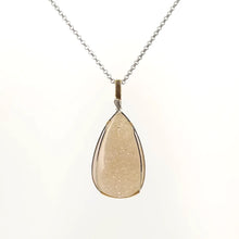 Necklace with a teardrop-shaped drusy agate pendant set in a sterling silver and Gold Filled Wire wrap and bail, on a white background (front view)