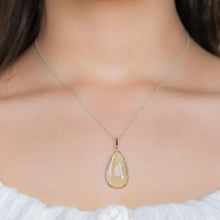 Close-up of a woman wearing a necklace with a teardrop-shaped drusy agate pendant set in a sterling silver and Gold Filled Wire wrap and bail