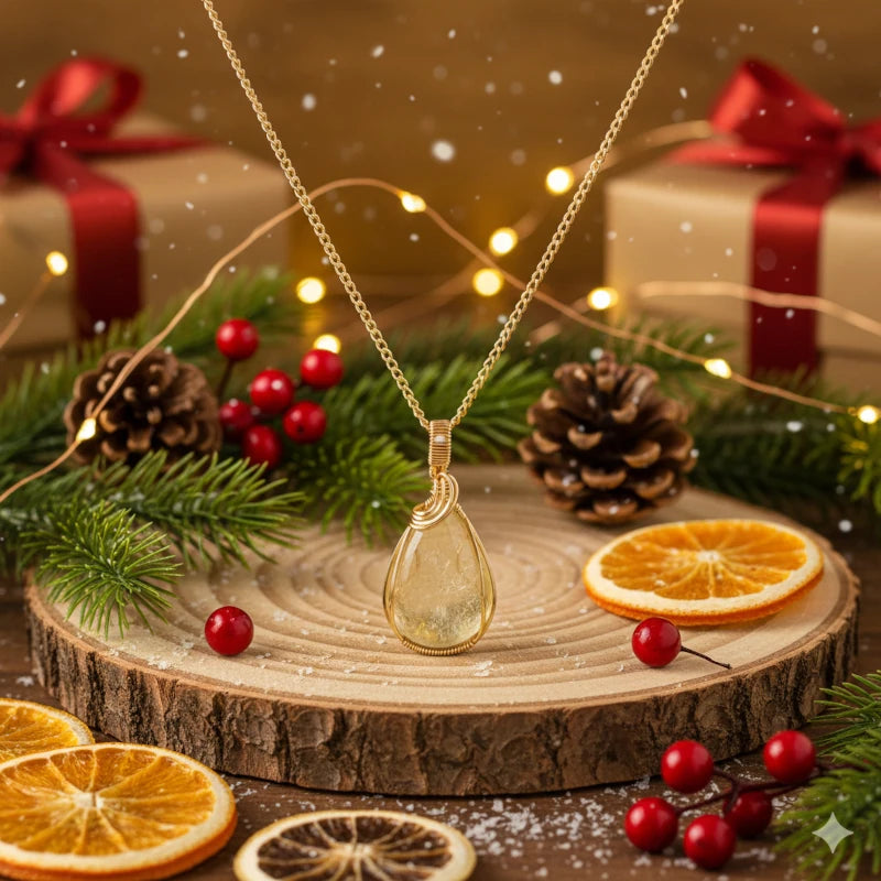 Wire-wrapped golden mica pendant on a wooden surface with Christmas decorations.