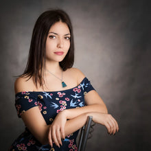 Woman wearing a necklace with a triangular Chrysocolla pendant featuring vibrant shades of blue and green with natural patterns, paired with Sterling Silver and Gold Filled Wire wrap and bail 