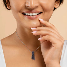 Close-up of a woman wearing a necklace with a Drusy Amethyst pendant sparkles with tiny crystal formations on a natural surface