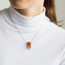 Close-up of a woman wearing a necklace with a cactus quartz crystal 
