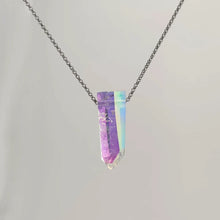Neckless with a Angel Aura Quartz pendant featuring a polished crystal point treated to reveal a shimmering display of iridescent colors, shifting between soft purples, blues, and hints of gold, on a white background.