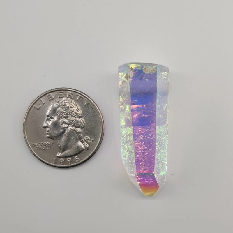 Angel aura quartz pendant next to a U.S. quarter on a gray background