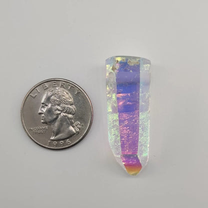 Angel aura quartz pendant next to a U.S. quarter on a gray background