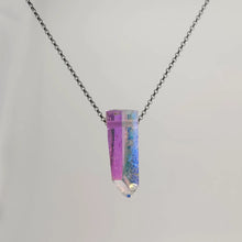 Neckless with a Angel Aura Quartz pendant featuring a polished crystal point treated to reveal a shimmering display of iridescent colors, shifting between soft purples, blues, and hints of gold, on a white background.
