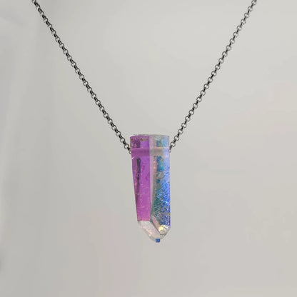 Neckless with a Angel Aura Quartz pendant featuring a polished crystal point treated to reveal a shimmering display of iridescent colors, shifting between soft purples, blues, and hints of gold, on a white background.