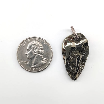 Drusy pyritized ammonite fossil pendant next to a quarter on a white background