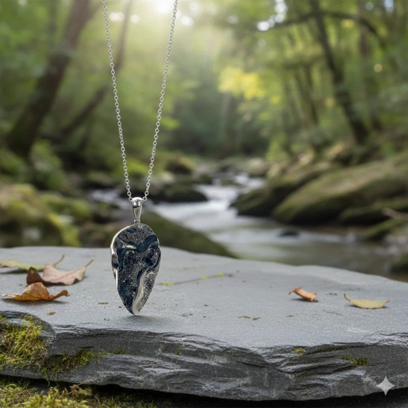 Necklace with a drusy pyritized ammonite fossil pendant on a rock in a forest setting