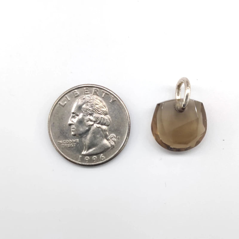 Smoky quartz pendant next to a quarter on a white background