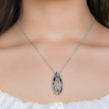 Close-up of a woman wearing a necklace with a Oco Geode pendant featuring natural crystal-lined interiors within an agate shell