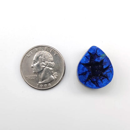 Teardrop-shaped azurite geode pendant next to a quarter on a white background