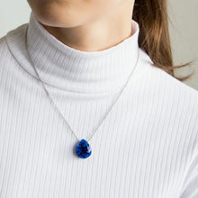 Close-up of a woman wearing a necklace with a teardrop-shaped Azurite Geode pendant displaying deep blue tones with natural crystal formations inside the geode 