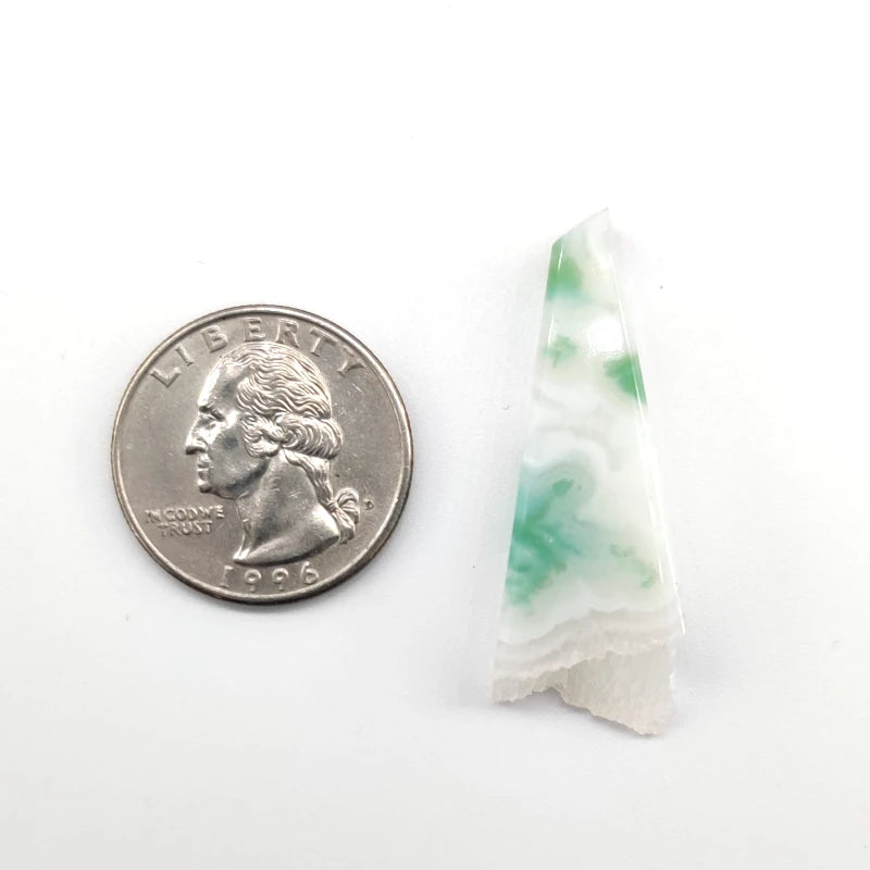 White agate stone pendant next to a quarter on a white background