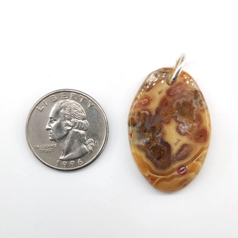 Oval-shaped agate pendant next to a U.S. quarter for size comparison on a white background