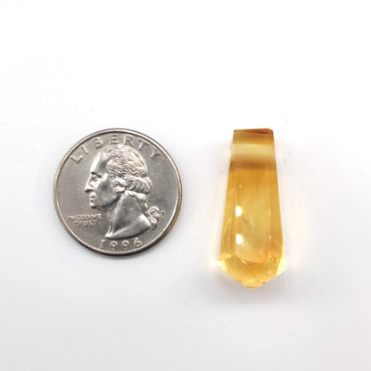 Yellow quartz next to a U.S. quarter on a white background