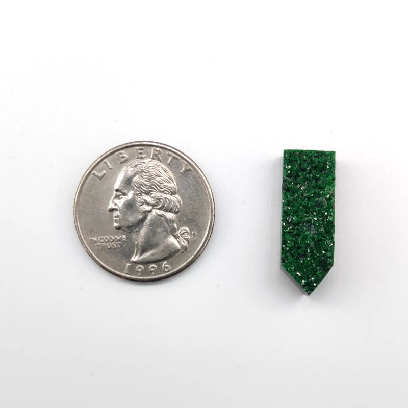 Green gemstone pendant next to a U.S. quarter on a white background