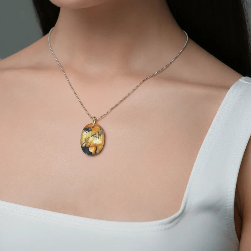 Necklace with a quartz pendant worn by a person, against a neutral background