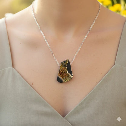 Necklace with a unique pendant worn by a person against a blurred natural background