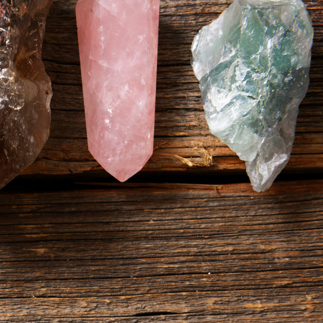 three pieces of quarts crystal laying on wood planks
